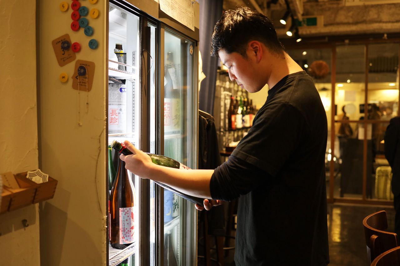 日本酒を選ぶ店員さん